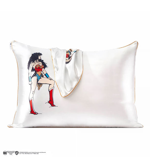 White satin Wonder Woman pillowcase with gold edge is fitted over a standard pillow with another pillowcase draped overtop