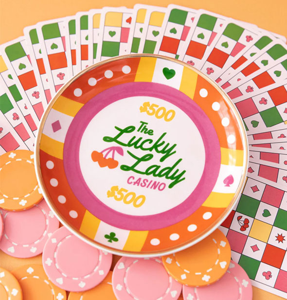 The Lucky Lady Casino trinket dish rests atop boldly colored playing cards and pastel poker chips