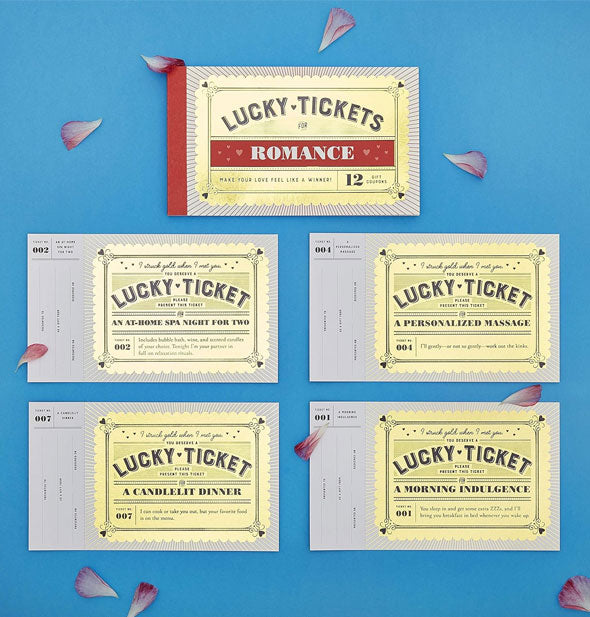 Samples from the Lucky Tickets for Romance booklet on a blue surface scattered with flower petals include spa night, massage, candlelit dinner, and morning indulgence