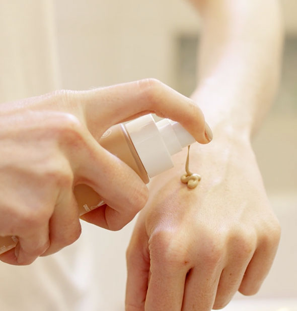 Model dispenses an application of tinted moisturizer to back of hand