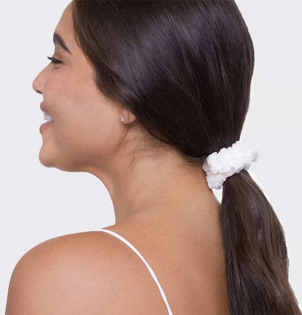 Smiling model wears a thick white fluffy cotton hair scrunchie in a low ponytail