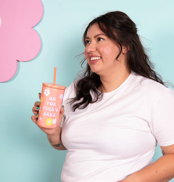 Smiling model holds an Oh for Fuck's Sake drink tumbler with lid and straw