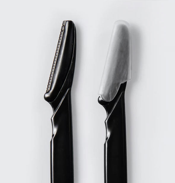 Closeup of the heads of two black Kitsch Dermaplaners—one with a plastic blade covering and one without