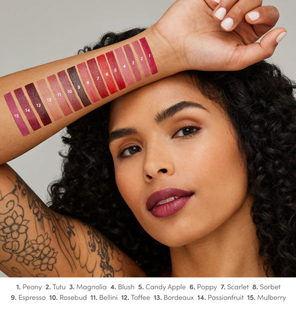 Model with medium skin tone holds forearm up to show each Jane Iredale ColorLuxe lipstick shade drawn on arm and labeled at bottom