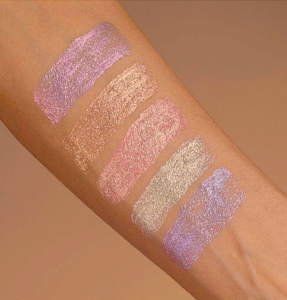 Model's arm wears samples of each shade of Unicorn Snot Eyelighter to show pigment and shimmer finish