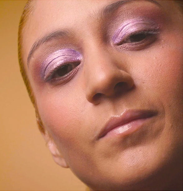 Model wears shimmery metallic purple eyeshadow