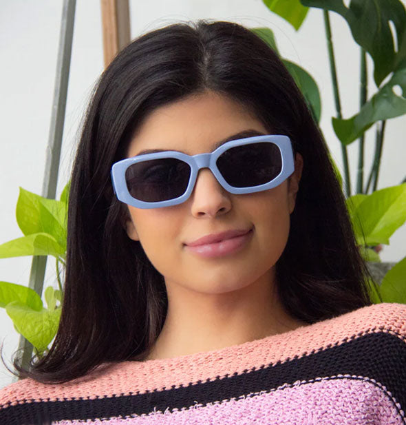 Model wears a pair of periwinkle blue sunglasses