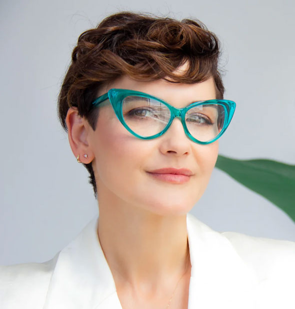 Model wears a pair of cat eye glasses with a clear turquoise frame