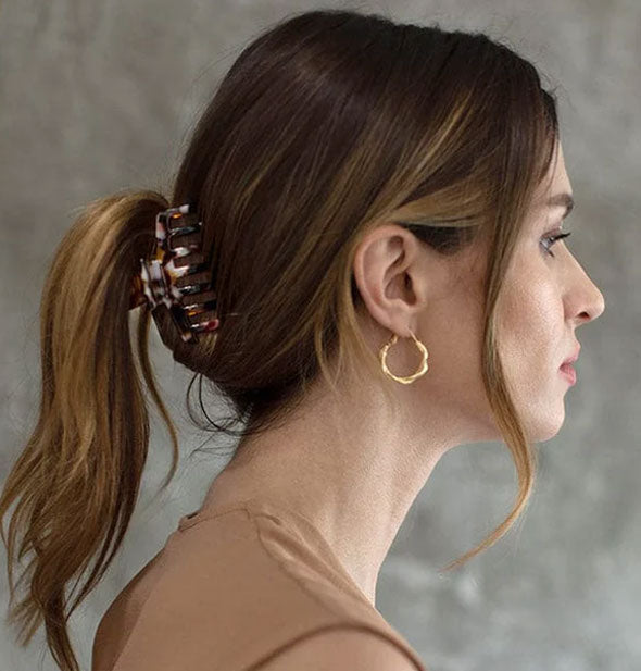 Model wears a claw clip in a low twisted ponytail