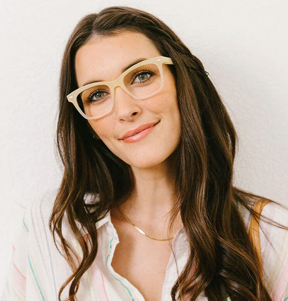 Smiling model wears a pair of squarish matte pale yellow glasses