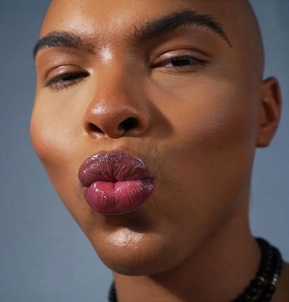 Model puckers shiny lips