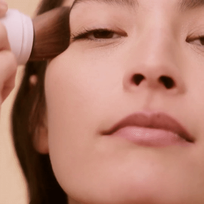 Model applies Jane Iredale Powder-Me SPF Dry Sunscreen to face