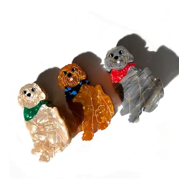 Three quartz-effect Goldendoodle dog hair clips: one apricot with green neckerchief, one amber-brown with blue neckerchief, and one gray streaked with red neckerchief