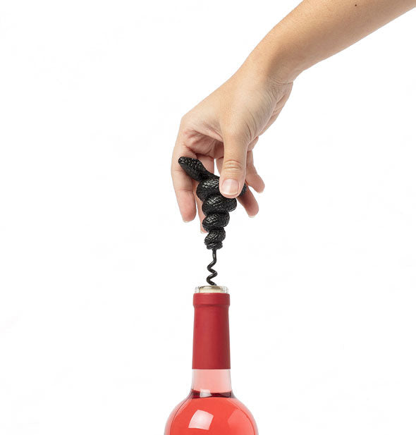 Model demonstrates use of a mamba corkscrew on a bottle of rosé