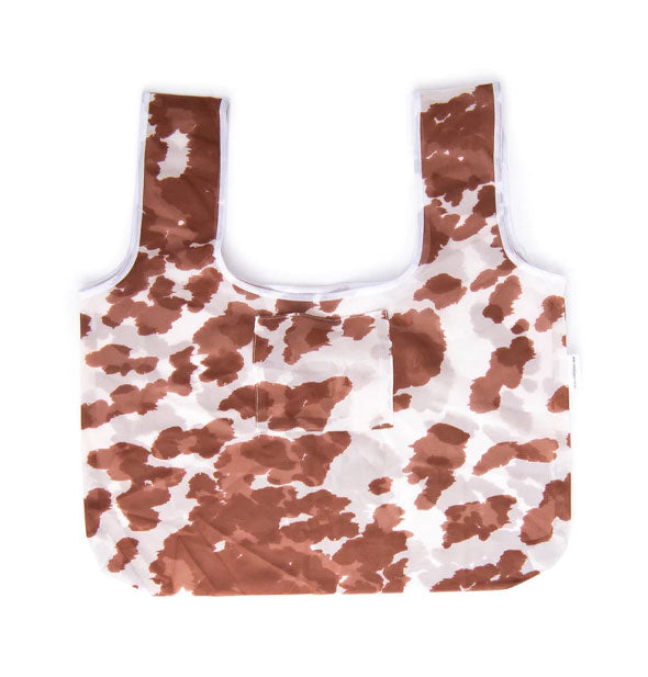 Brown and white cowhide print bag with wide handles and exterior slip pocket