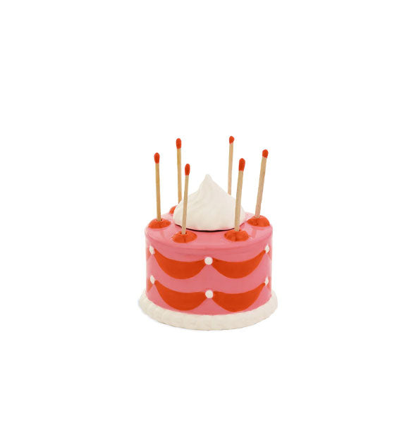 Cake match holder shown with six red-tipped wooden matchsticks sticking out of the top