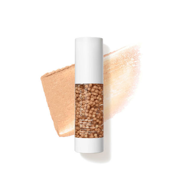 Bottle of Jane Iredale HydroPure Tinted Serum with color capsules visible through clear packaging and a sample application behind in the shade Medium 4