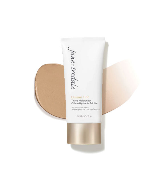 White and gold tube of Jane Iredale Dream Tint Tinted Moisturizer with enlarged smeared product application behind in shade Medium Dark