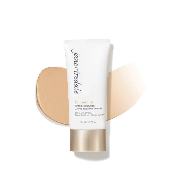 White and gold tube of Jane Iredale Dream Tint Tinted Moisturizer with enlarged smeared product application behind in shade Medium Light