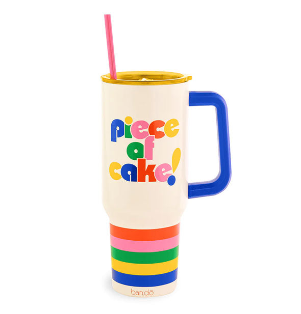 Large white drink tumbler with rainbow band base, blue handle, yellow lid, and pink straw says, "Piece of cake!" in multicolored lettering