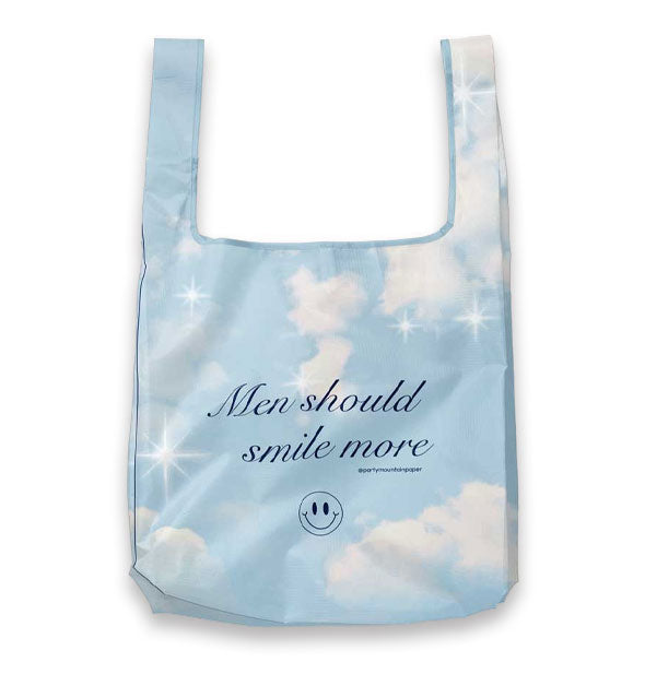 Tote bag with all-over blue sky, clouds, and stars pattern says, "Men should smile more" in dark blue script lettering with a smiley face graphic