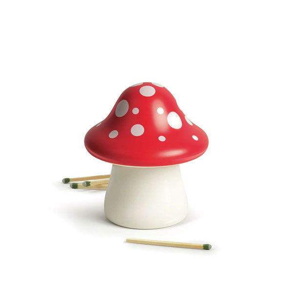 Red and white spotted mushroom staged with wooden matchsticks