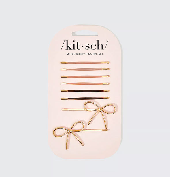 Set of eight bobby pins, six with neutral enamel covering over gold hardware and two with bow accent details, on light pink Kitsch product card