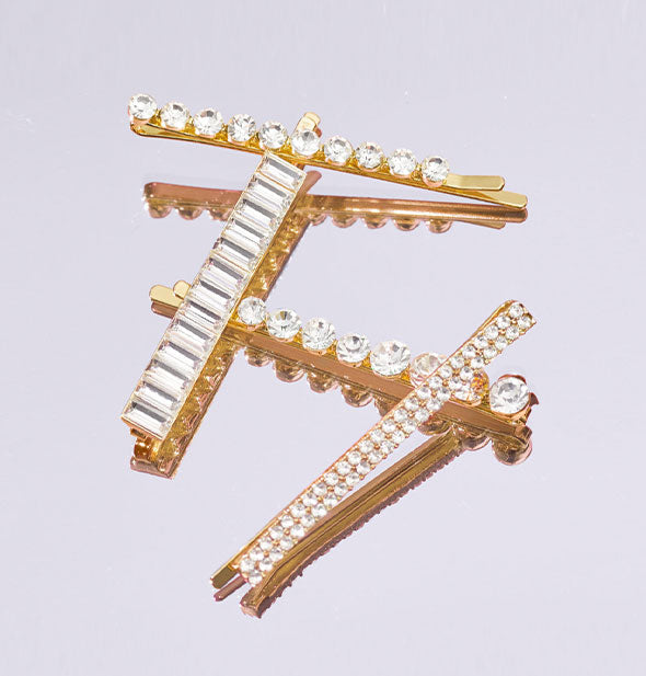 Gold-toned bobby pins with rhinestone accents in a variety of sizes and shapes