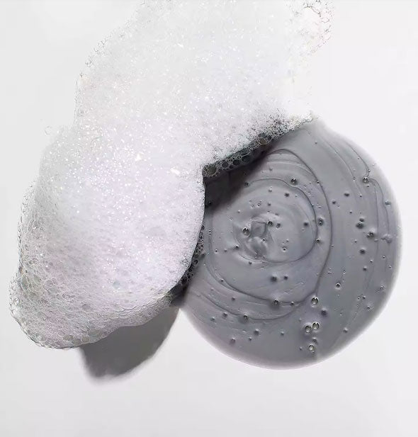 Closeup of a dollop of gray-colored shampoo and suds