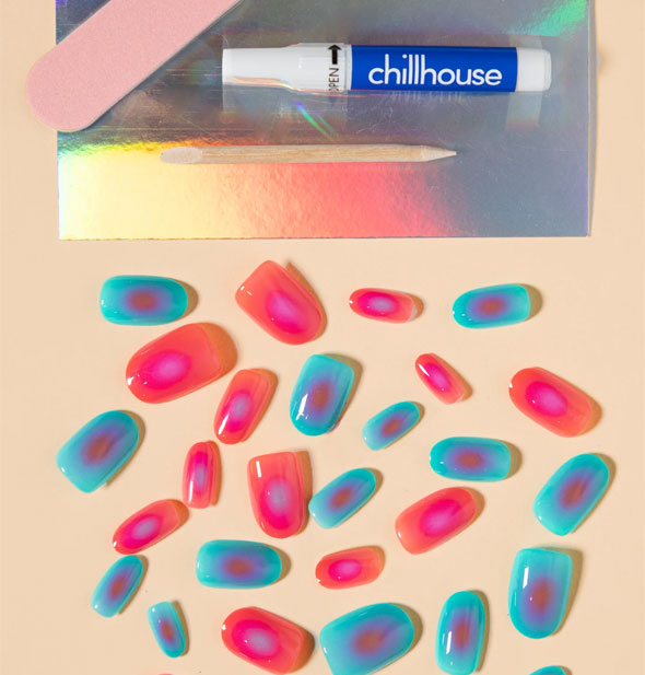 Contents of the Mood Ring Chill Tips press-on nails set: Pink and blue nails in an assortment of sizes, pink file, wooden cuticle pusher, and glue tube
