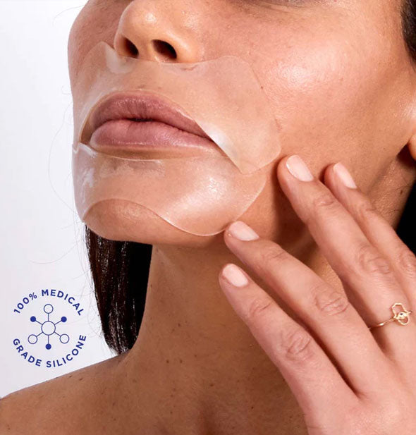 Model gently touching face wears clear silicone patches directly above and below lips; a seal to the left says, "100% medical grade silicone" with infographic