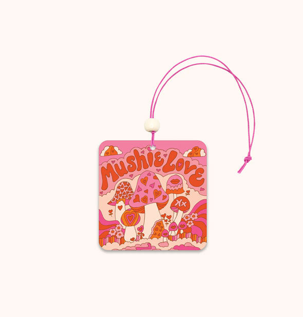 Rounded square car air freshener on pink string with white accent bead features a whimsical retro red, pink, and white Mushie Love mushroom design