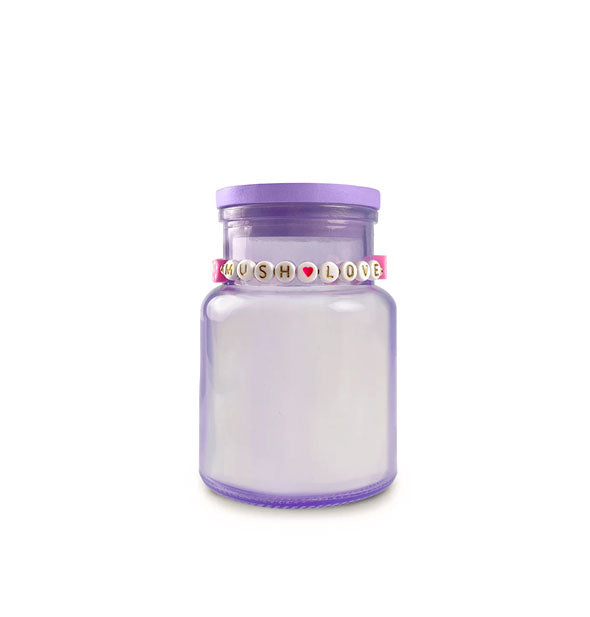 Purple glass candle jar with "Mush Love" beaded bracelet around its neck