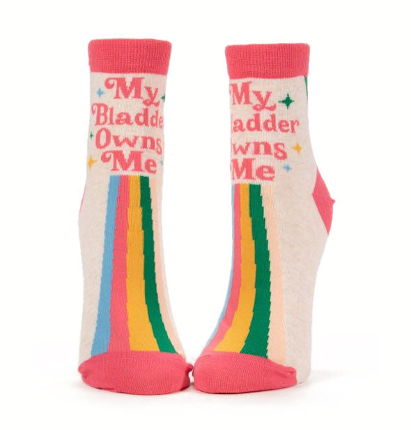 Light-colored socks with pink accents and rainbow motif each say, "My Bladder Owns Me" in pink lettering accented with stars