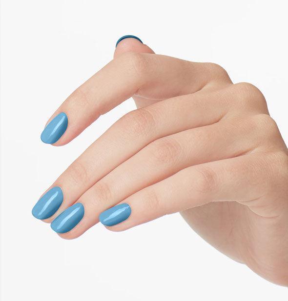 Model's hand wears a medium shade of blue nail polish