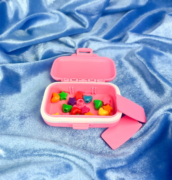 Pill pill case with colorful heart and star beads inside is shown with section dividers removed