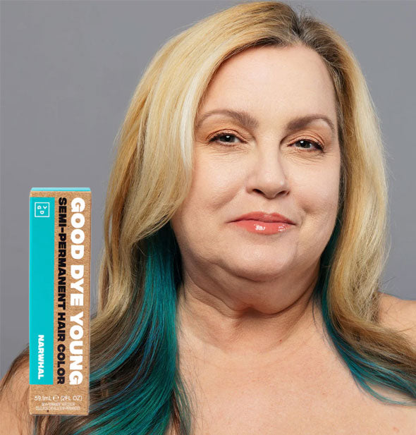 Model wears blue-green under-streaks in dark hair; box of Good Dye Young Semi-Permanent Hair Color in shade Narwhal is inset at bottom left