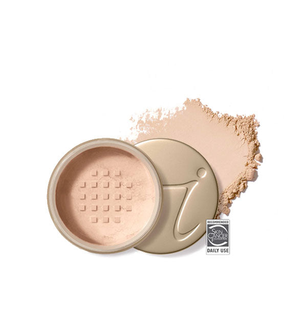Opened round Jane Iredale loose powder compact with stamped gold lid and product application behind it in shade Natural