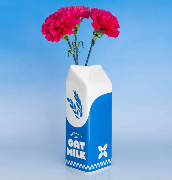 Oat Milk ceramic carton vase is staged with pink carnations in it