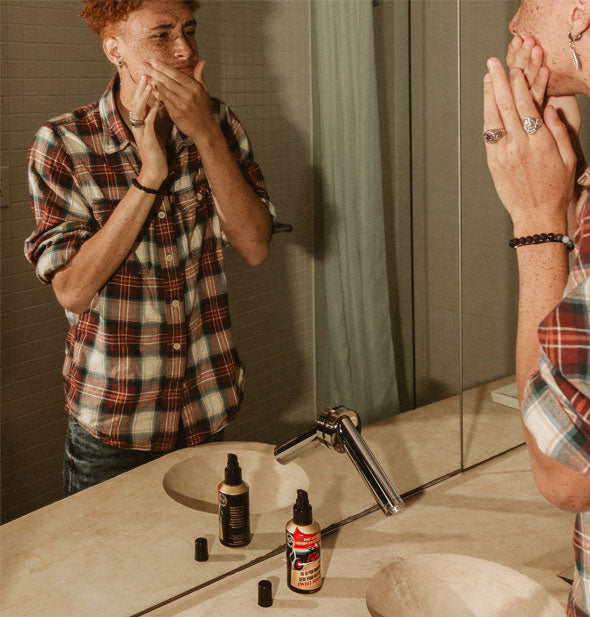 Model applies Octane 100 Face Moisturizer in front of a bathroom mirror