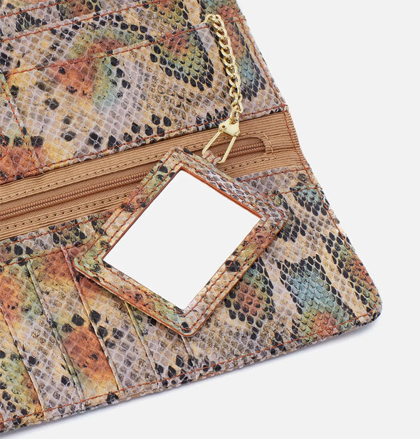 Closeup of multicolored snakeskin print leather wallet interior with mirror attached to gold chain hardware
