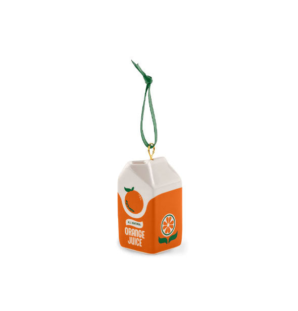 Ornament hanging from a green ribbon resembles an orange and white orange juice carton