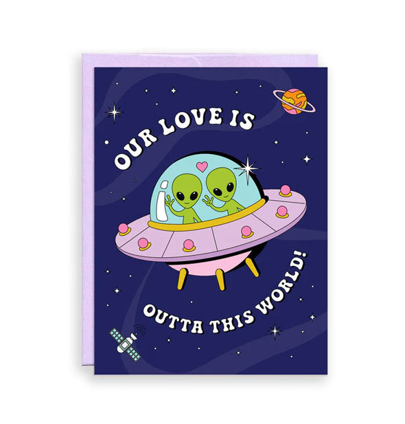 Dark blue greeting card backed by a purple envelope features an illustration of two green aliens floating through space in a pink spaceship and the message, "Our love is outta this world!" in white lettering