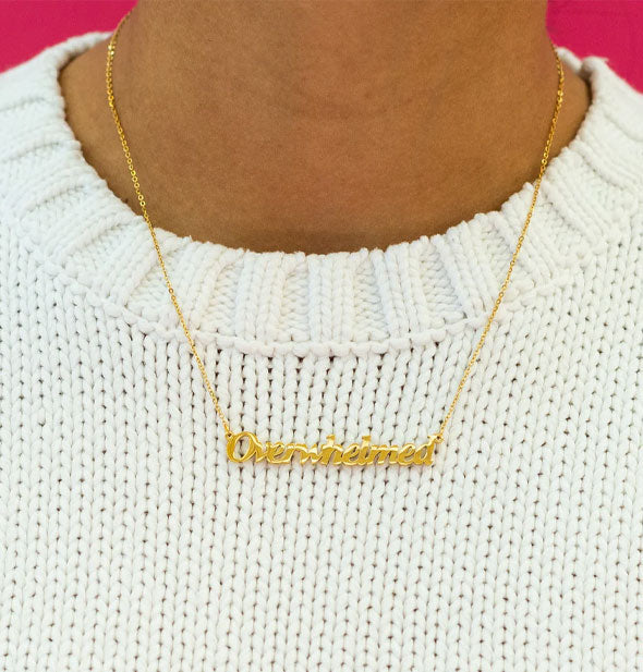 Model wears a gold Overwhelmed nameplate necklace