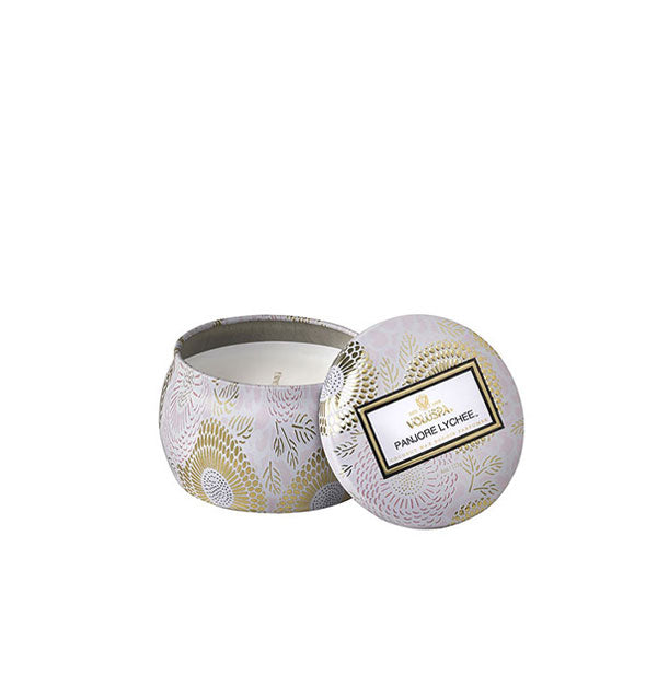 White and gold metallic Panjore Lychee Voluspa candle tin with lid set to the side