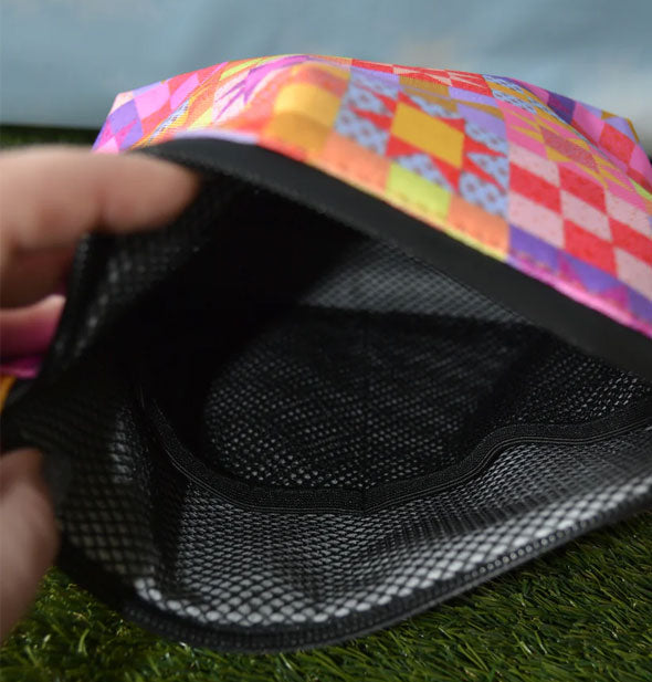 Model's hand holds open a Patchwork Quilt Smell-Proof Stash Bag to show mesh lining with pocket storage