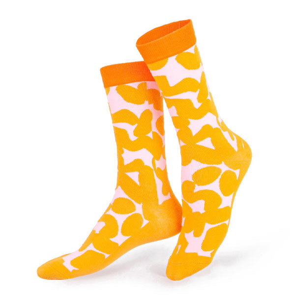 Pair of light pink socks with orange top bands and all-over oblong circular orange print