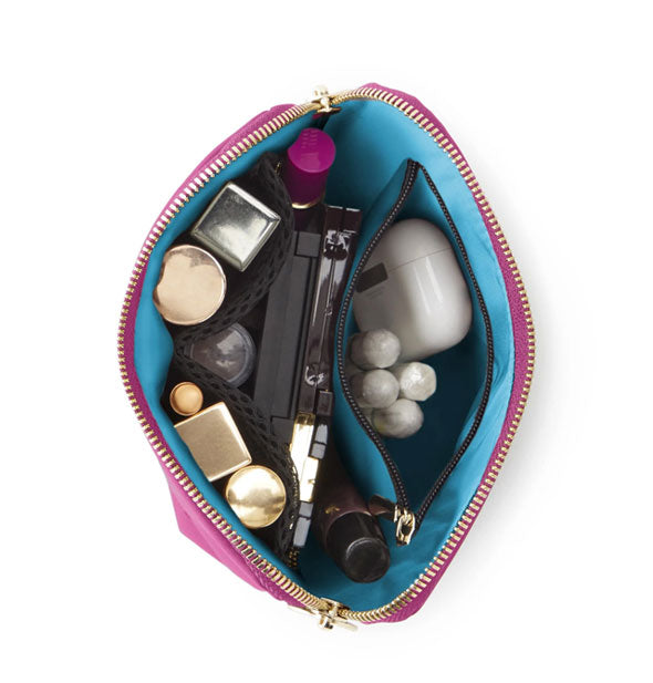 Top view of opened Everyday Makeup Bag reveals blue lining and cosmetic and toiletry items organized inside