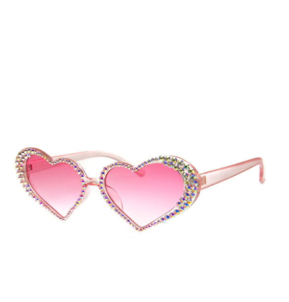Clear pink heart-shaped sunglasses with rhinestones bordering pink gradient lenses