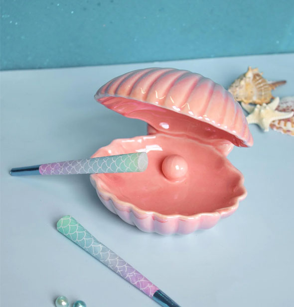 Iridescent pink ceramic clamshell ashtray with rolled cigarette props